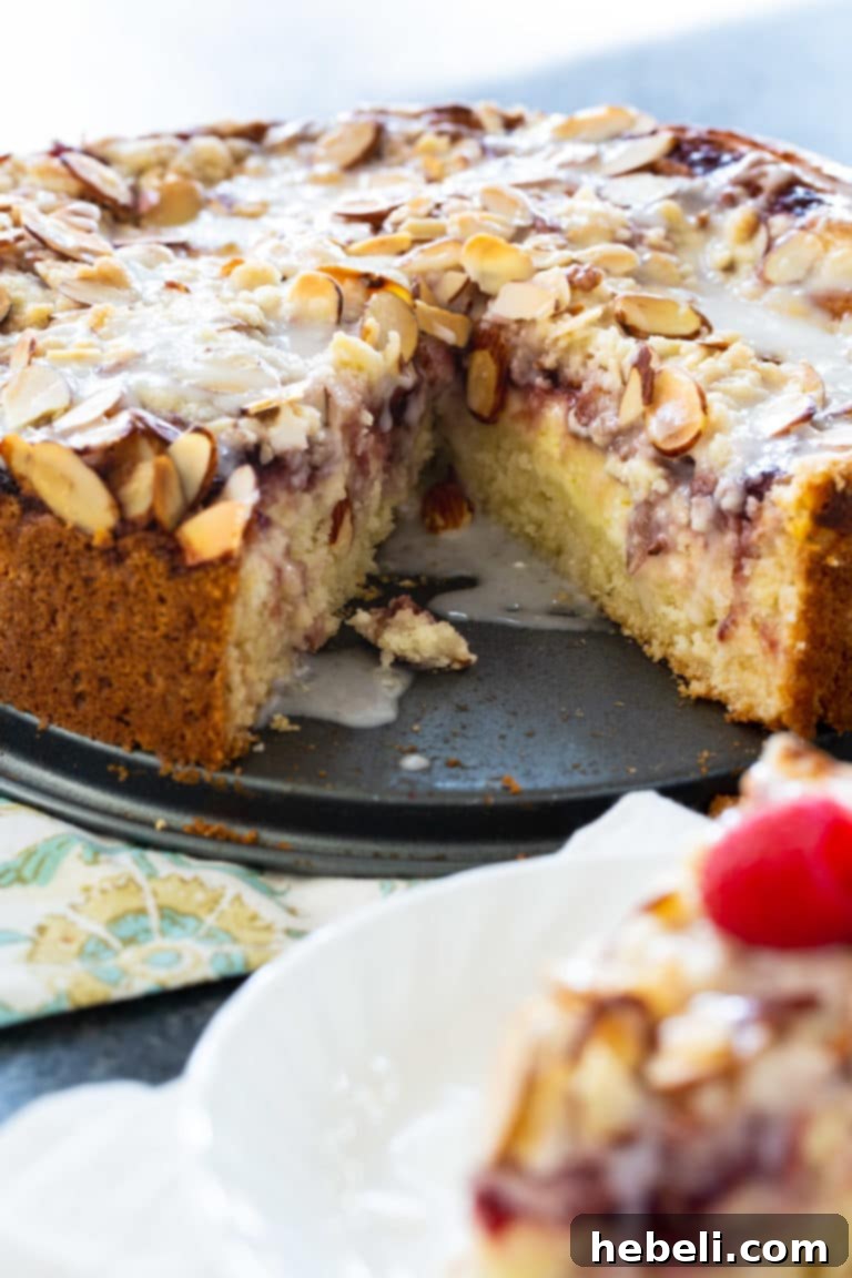 Raspberry Cream Cheese Swirl Coffee Cake 4 A stunning top-down view of the whole Raspberry Cream Cheese Coffee Cake, showcasing its vibrant raspberry swirls, creamy white cream cheese layer, and golden almond crumb topping, perfectly baked and ready to be sliced for a gathering.