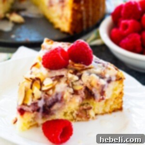 Raspberry Cream Cheese Swirl Coffee Cake 5 A beautifully presented slice of Raspberry Cream Cheese Coffee Cake, showing its delightful layers, ready to be enjoyed with a hot cup of coffee.