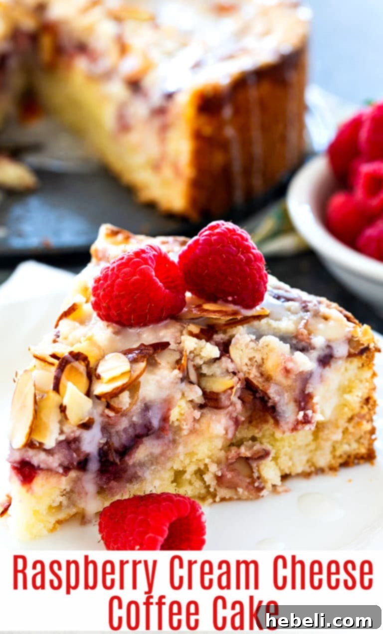 Raspberry Cream Cheese Swirl Coffee Cake 6 A gorgeous, thick slice of Raspberry Cream Cheese Coffee Cake, elegantly drizzled with sweet glaze, showcasing its fluffy texture and rich layers. It's ready to be savored, perhaps alongside a freshly brewed cup of coffee.