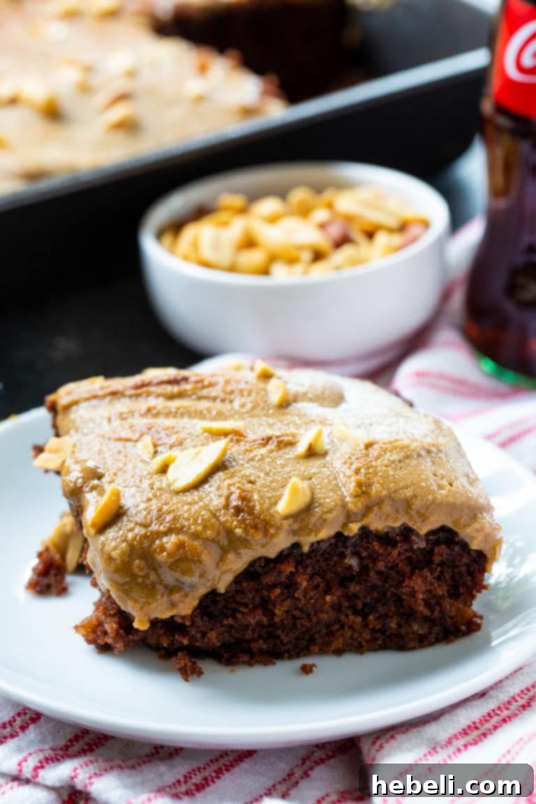 An appetizing close-up of the Coca-Cola Cake with Broiled Peanut Frosting, highlighting the texture of the toasted peanuts and the perfectly caramelized surface of the frosting.