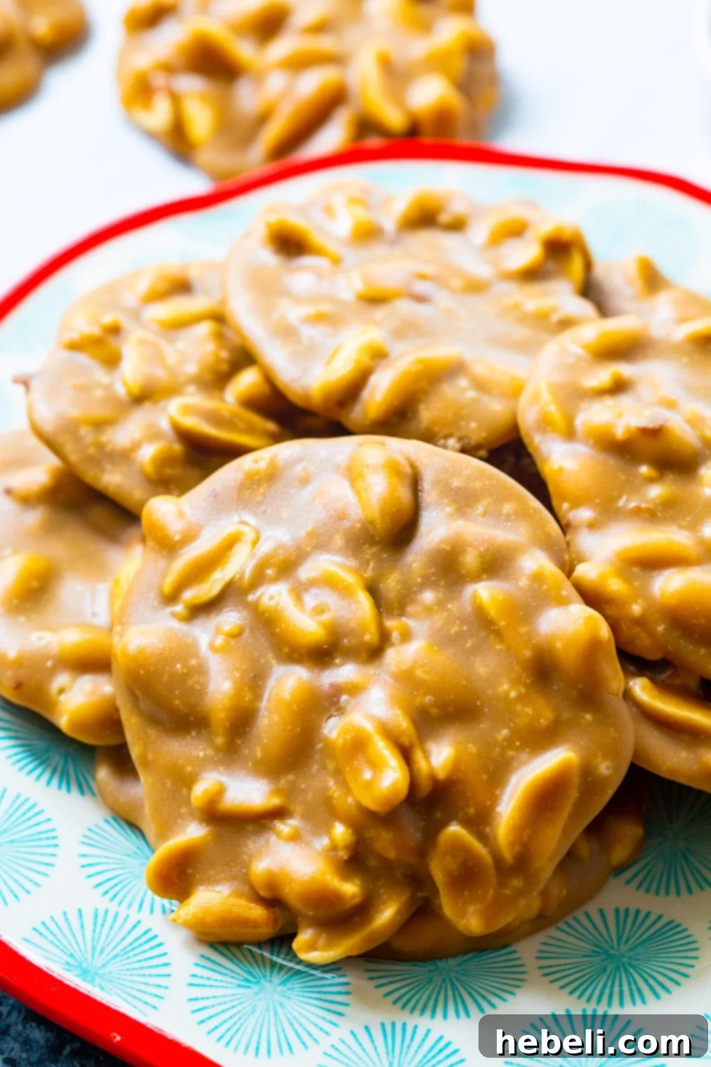 A stack of golden Peanut Pralines served on a festive blue and red plate, perfect for holidays.