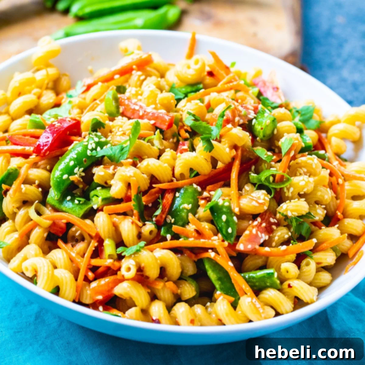 Asian Fusion Pasta Salad 2 A large white bowl filled with vibrant Asian Pasta Salad, showcasing the colorful mix of pasta, vegetables, and dressing.