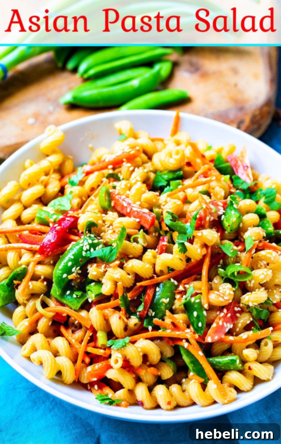 Asian Fusion Pasta Salad 6 A large, beautifully presented bowl of Asian Pasta Salad, ready to be enjoyed. The salad is garnished with peanuts and cilantro, highlighting its fresh ingredients.