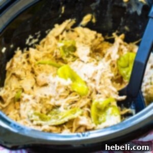 Crock Pot Creamy Mississippi Chicken in a black slow cooker, garnished for serving.