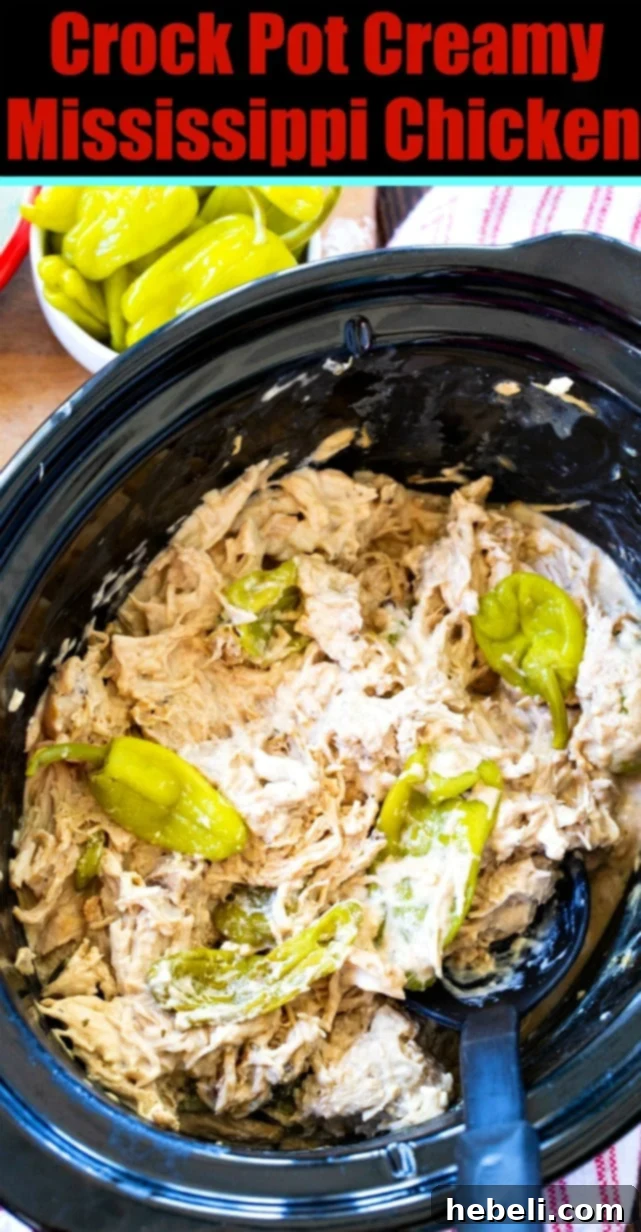 Crock Pot Creamy Mississippi Chicken with whole pepperoncini peppers and a spoon, highlighting the creamy texture.