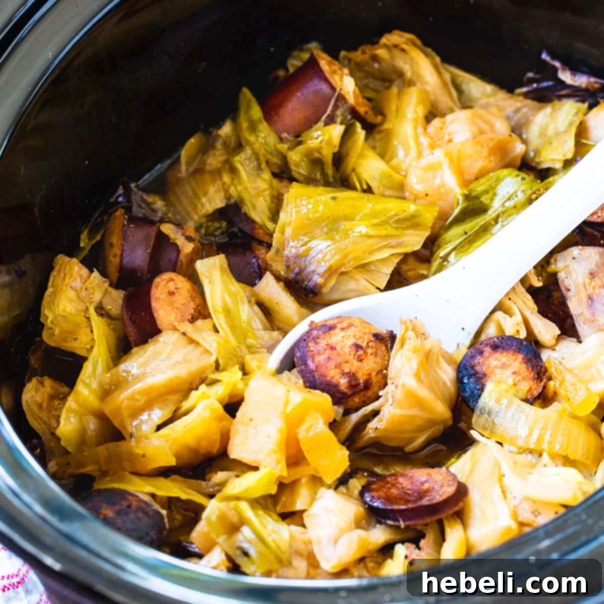Hearty Slow Cooker Cabbage and Kielbasa 2 Crock Pot Cabbage and Kielbasa in black slow cooker, steaming hot and ready to serve.