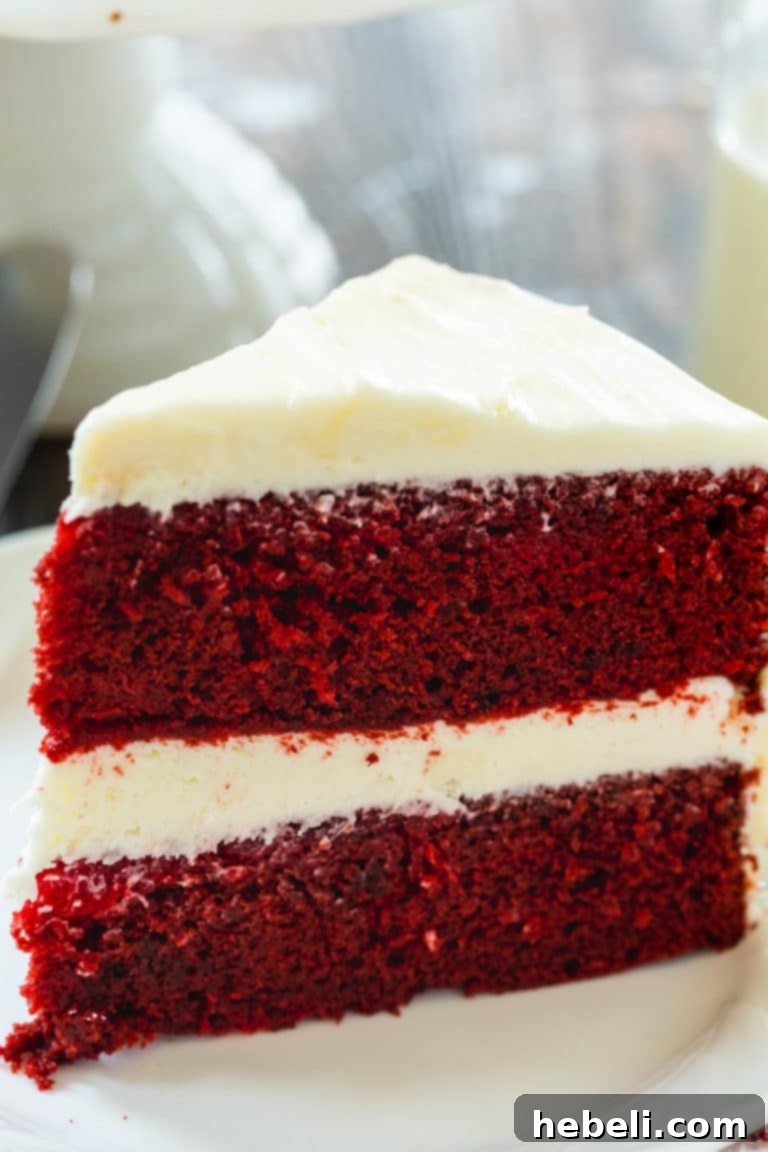 A beautifully frosted Red Velvet Cake, showcasing its signature red layers and fluffy cream cheese topping.