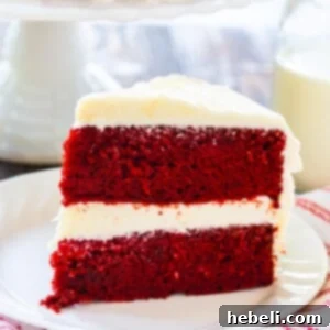 A beautifully decorated slice of Red Velvet Cake on a plate, highlighting the rich frosting and cake texture.