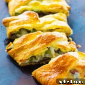 A freshly baked Cheesesteak Crescent Braid, sliced and ready to serve, showcasing the golden crust and savory filling.