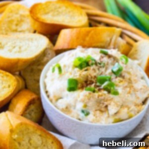 Crock Pot Crab Artichoke Dip in bowl surrounded by toasted baguette slices.