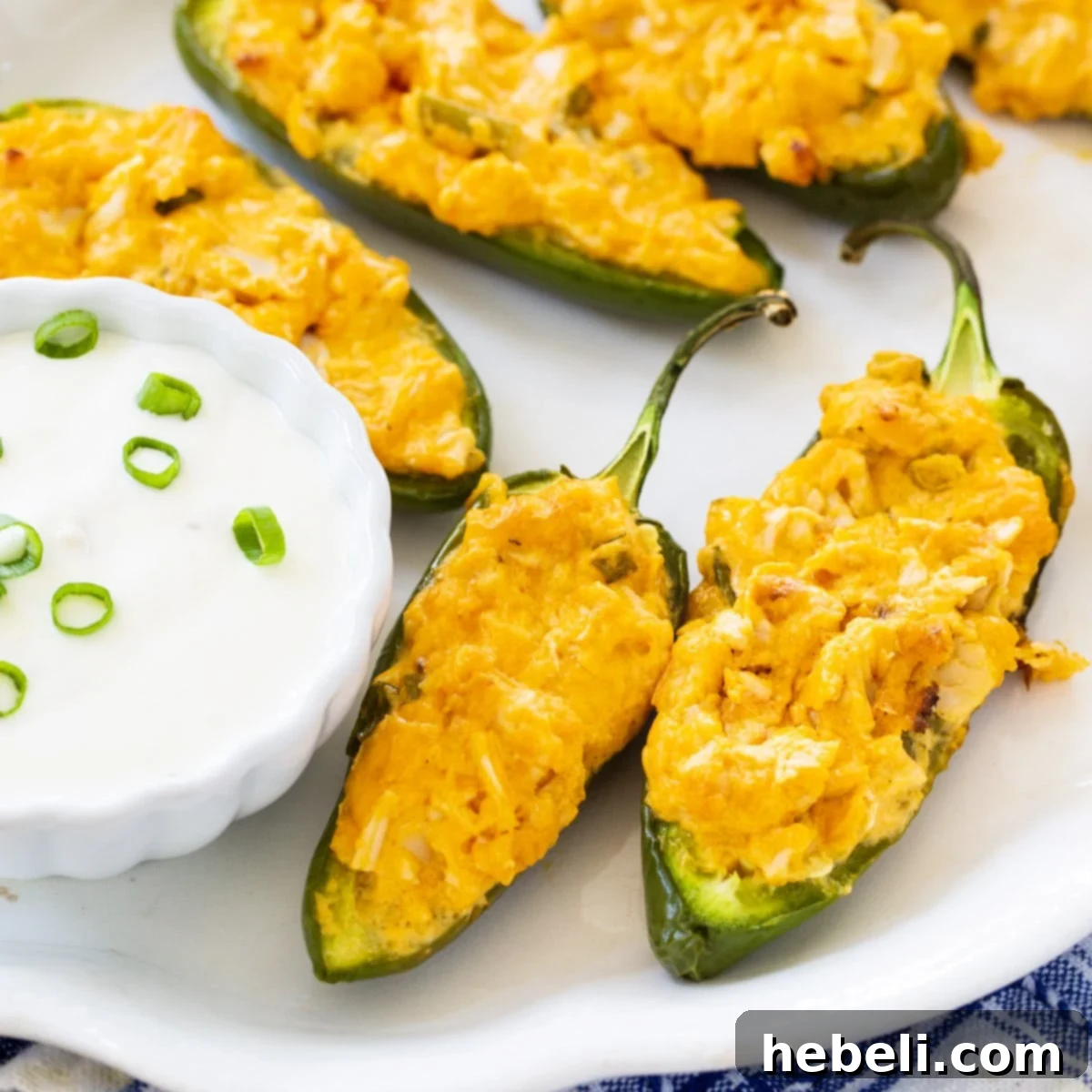 Buffalo Chicken Jalapeno Poppers on plate with bowl of blue cheese dip.