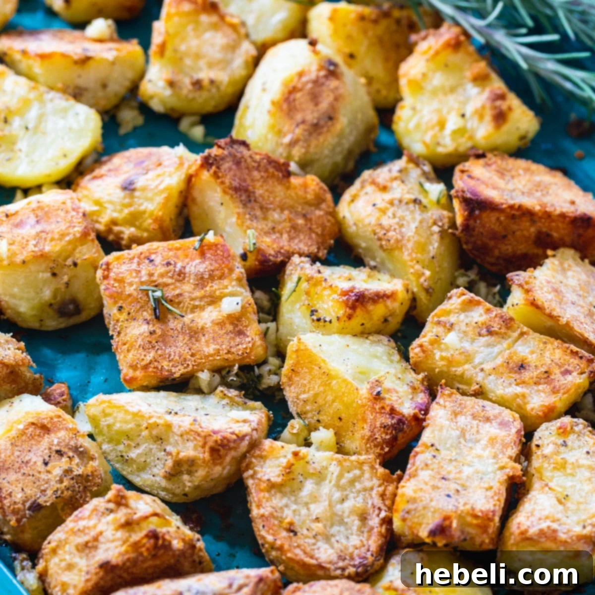 Golden brown and perfectly crispy roasted potatoes on a baking sheet, ready to be served.