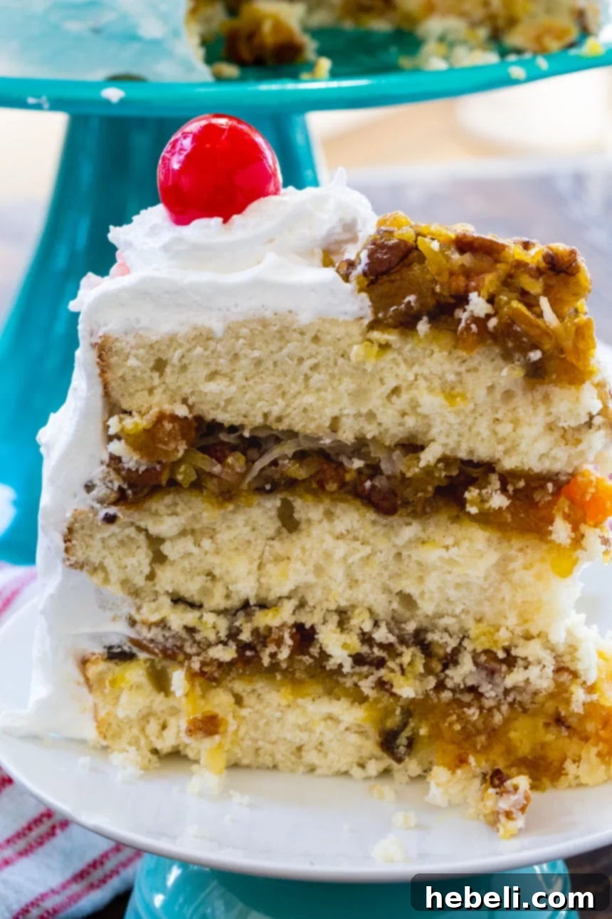 A beautifully decorated Southern Lane Cake, topped with vibrant maraschino cherries and enveloped in smooth, white 7-Minute Frosting.