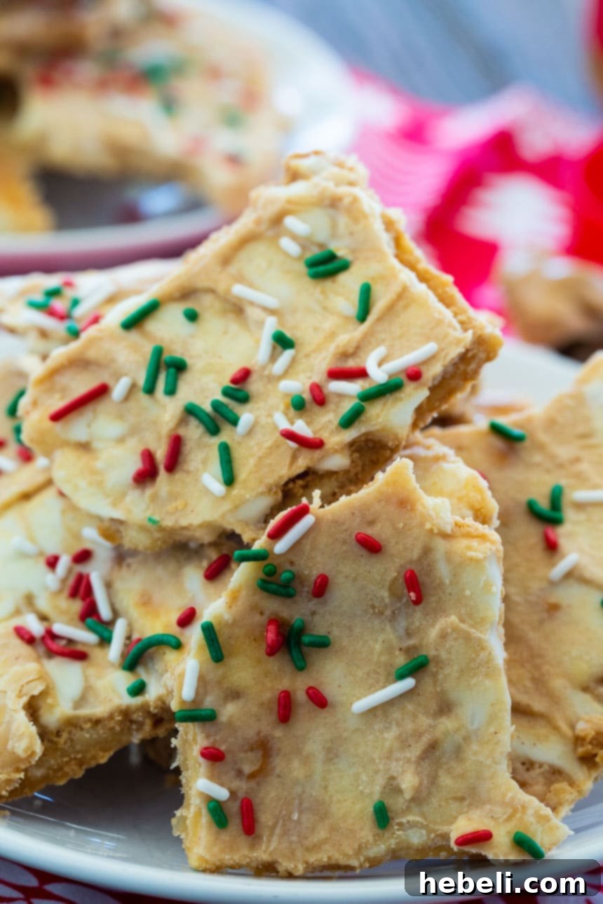 Decadent White Chocolate Peanut Butter Christmas Crack 3 Close-up of a large piece of White Chocolate and Peanut Butter Christmas Crack, showing the distinct layers and crunchy texture.