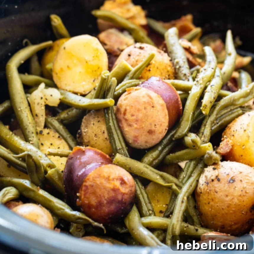 Crock Pot Sausage, Potatoes, and Green Beans cooking in a slow cooker, showcasing the vibrant ingredients.