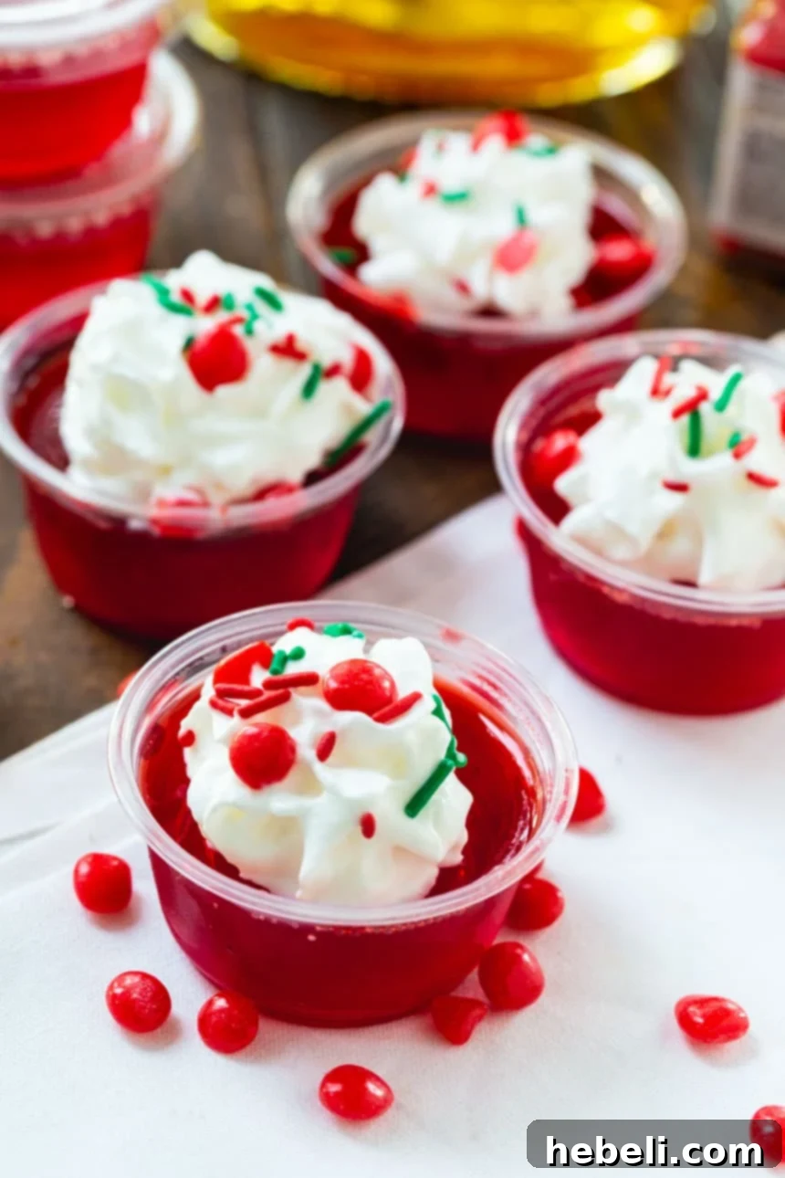 Fireball Jell-O Shots 5 Neatly arranged Fireball Jello Shots in clear disposable cups, some with lids, ready to be chilled.