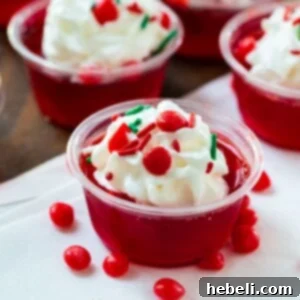 Fireball Jello Shots in a small cup, garnished with whipped cream and sprinkles.