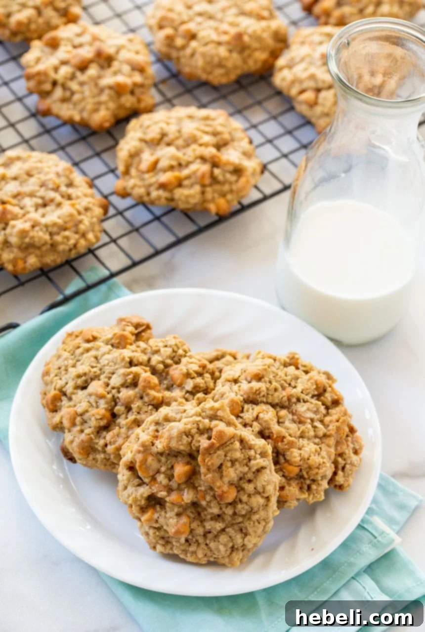 A close-up of a stack of golden-brown Oatmeal Butterscotch Cookies, highlighting their soft texture and visible butterscotch chips.