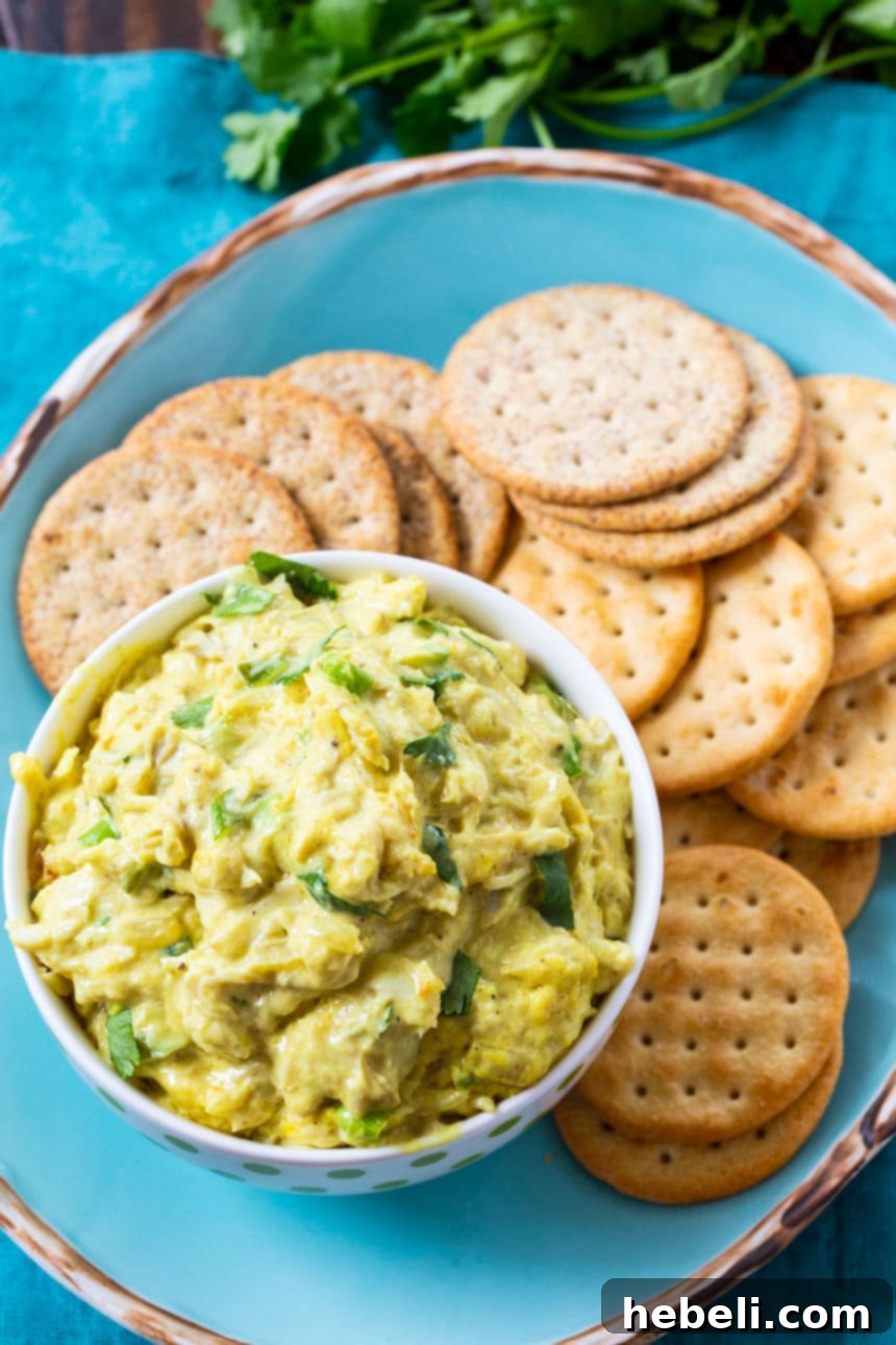 Aromatic Curried Crab Dip 3 Overhead of crab dip on a plate with crackers.