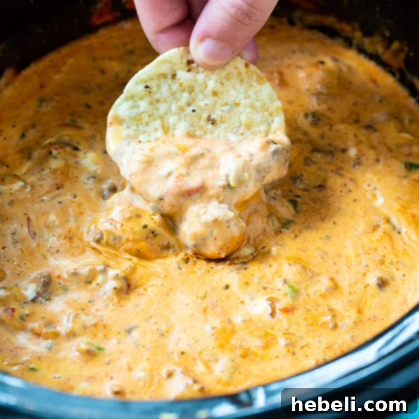 Creamy Slow Cooker Taco Dip 2 Slow Cooker Cream Cheese Taco Dip bubbling hot in a slow cooker, ready to be served.