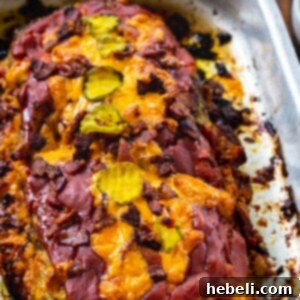 Loaded Bacon Cheeseburger Meatloaf 5 Meatloaf topped with bacon and cheddar cheese in baking pan.