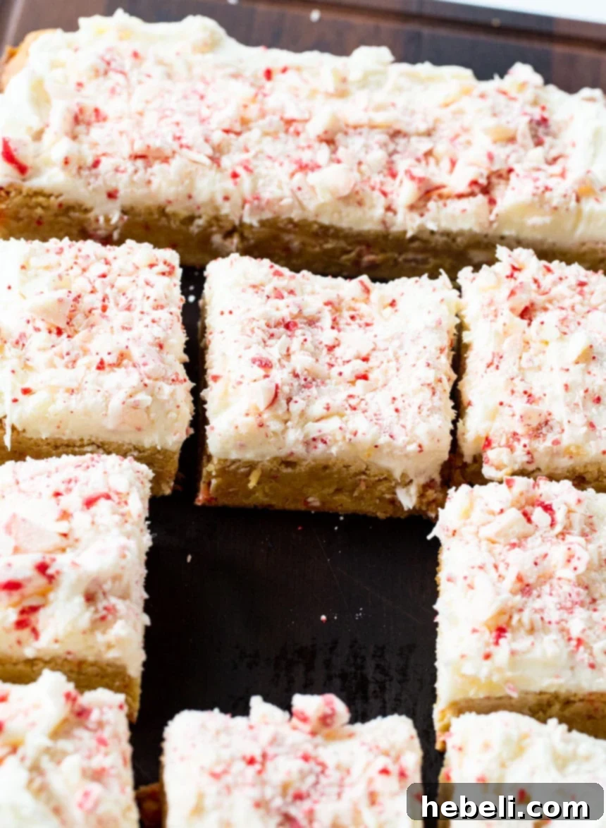Freshly baked Peppermint Blondies, cut into neat squares and arranged on a wooden cutting board.
