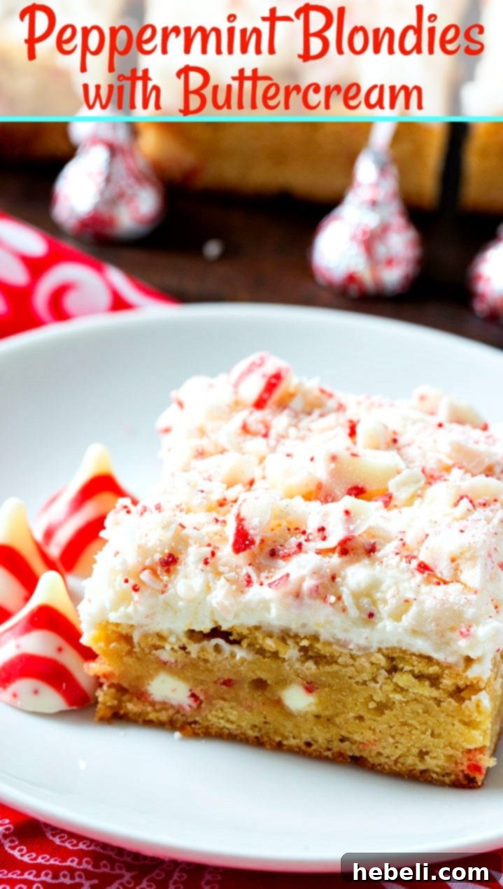 A festive Peppermint Blondie with buttercream, decorated with crushed candy cane pieces, held in hand, showing its delicious texture.