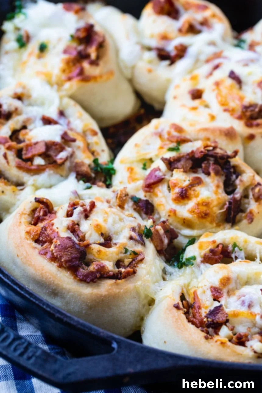 Delicious Bacon and Cheese Pizza Pinwheels baking in a hot cast iron pan, golden brown and bubbly.