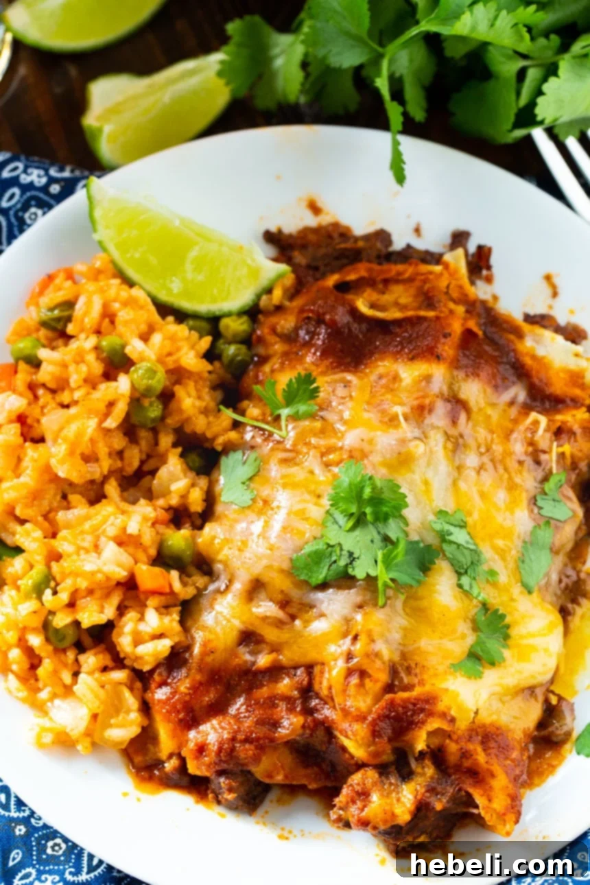 Hearty Beef Enchiladas 3 Close-up of a pan of From Scratch Red Enchiladas with Beef, showcasing the rich red sauce and melted cheese.