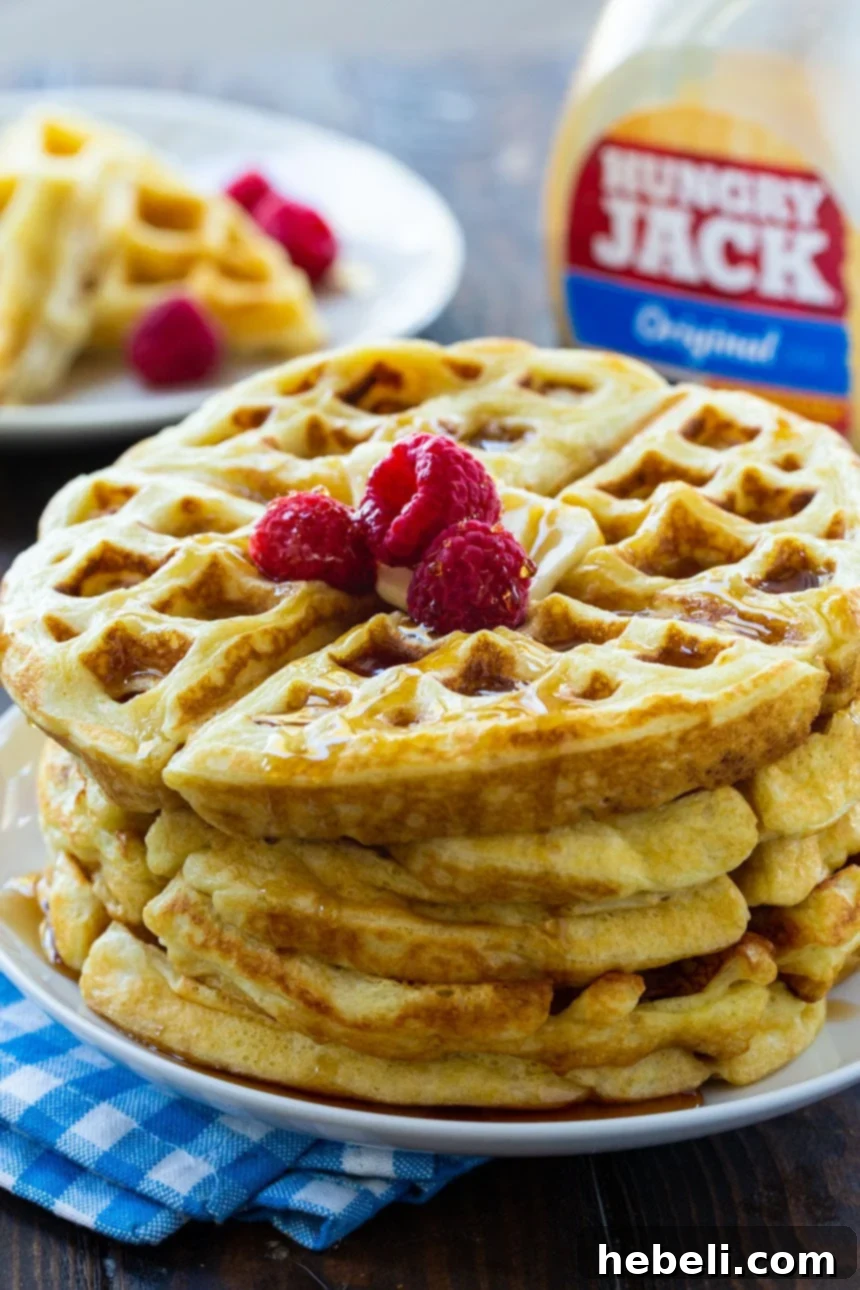 A close-up view of the golden, textured surface of an Overnight Yeast Waffle, ready for a delicious topping.