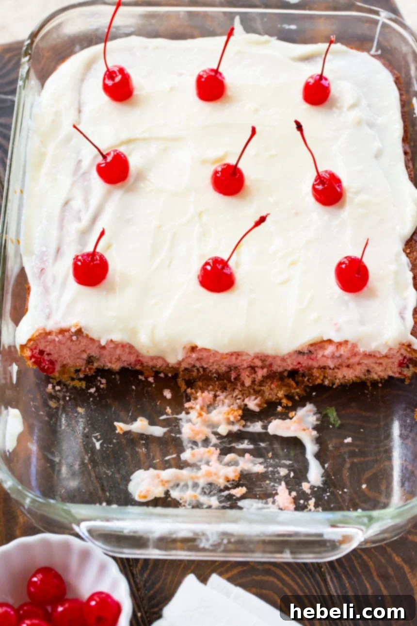 A close-up of the Cherry Sheet Cake batter, showcasing the vibrant red maraschino cherries interspersed within the light pink mixture, ready to be baked.