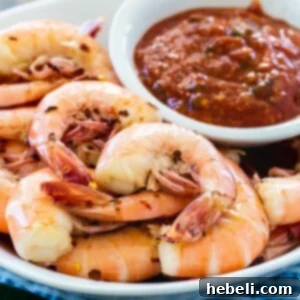 Drunken Shrimp with Fire Roasted Jalapeno Kick 5 Shrimp cooked in beer served with a small bowl of roasted jalapeno cocktail sauce, garnished with fresh herbs.