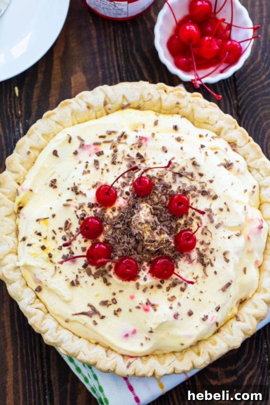 A beautifully set No-Bake Maraschino Cherry Pie, highlighting its vibrant red cherries and smooth texture, ready to be sliced and served, emphasizing its no-bake simplicity.