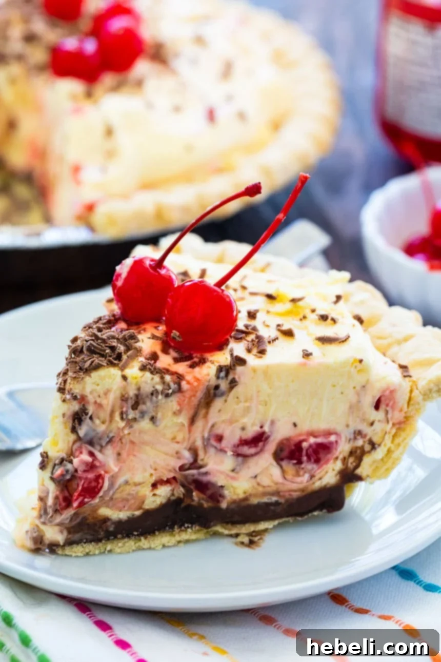A close-up of the smooth, creamy Cherry Almond Mousse Pie filling, garnished with grated chocolate and a single maraschino cherry, highlighting its luxurious texture.