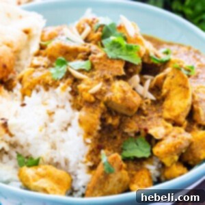 Chicken Korma over rice in a light blue bowl.