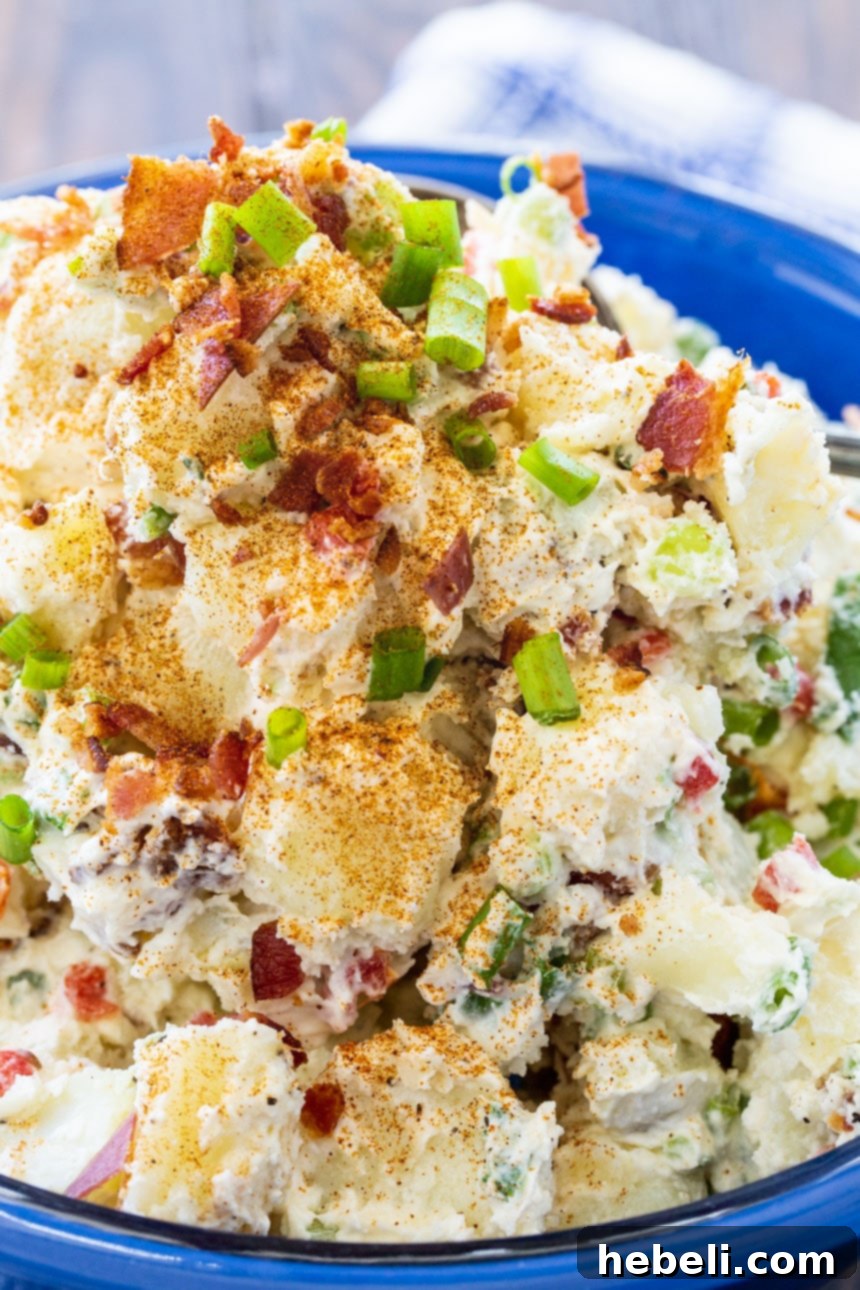 Loaded Bacon Potato Salad 3 Close-up of creamy bacon potato salad in a decorative blue serving bowl, highlighting the texture and bacon pieces, ready for serving.