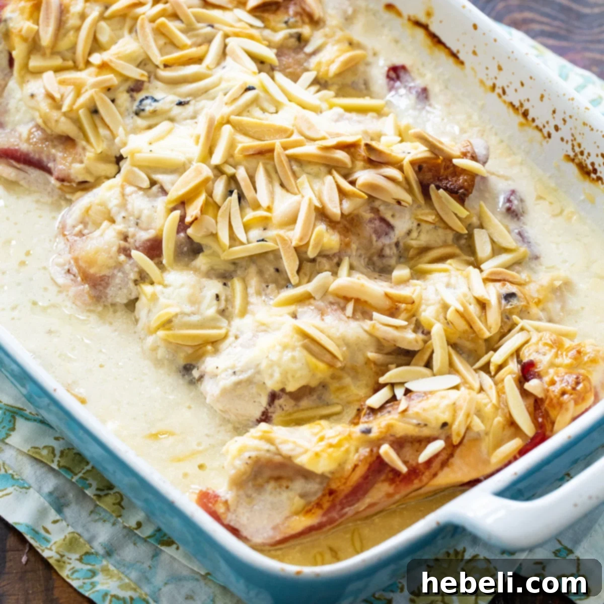 Creamy Company Chicken Bake 2 Delicious golden-brown Chicken and Sour Cream Bake with crispy bacon and almonds, freshly baked in a casserole dish, ready to be served as a comforting family meal.