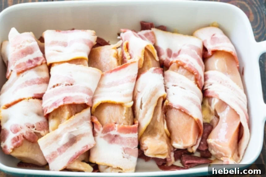 Creamy Company Chicken Bake 4 Thinly sliced chicken breast wrapped in a strip of bacon, ready to be placed in the casserole dish.