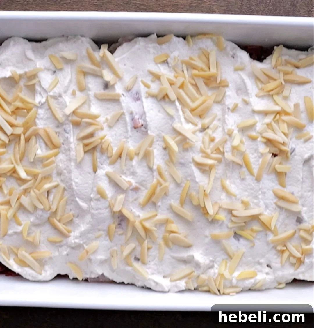 Creamy Company Chicken Bake 6 The Chicken and Sour Cream Bake, topped with slivered almonds, ready to be placed in the oven for baking.