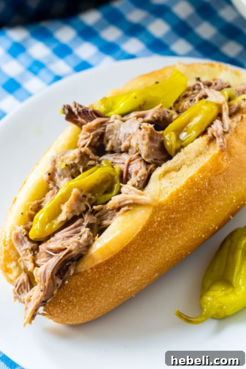 Close-up of Slow Cooker Mississippi Pulled Pork with a generous amount of pepperoncini peppers, ready for shredding.