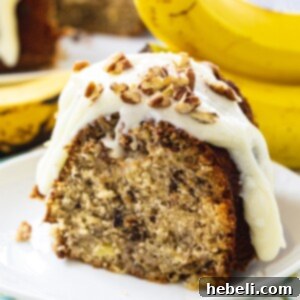 Slice of Hummingbird Bundt Cake on a plate, featuring the cream cheese glaze.