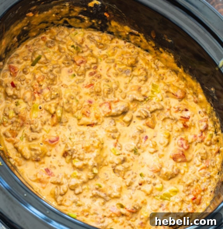 Creamy Crockpot Bacon Cheeseburger Dip served warm in a slow cooker, garnished with fresh herbs and ready for dipping.