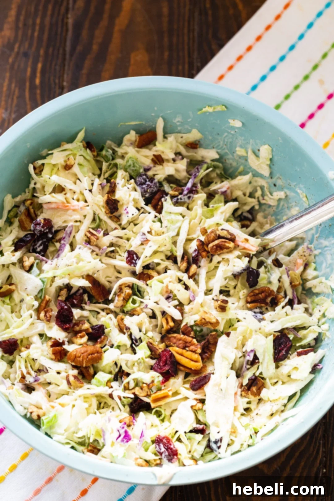 Close-up shot of Cranberry Coleslaw in a large blue bowl, highlighting the texture and colorful ingredients.