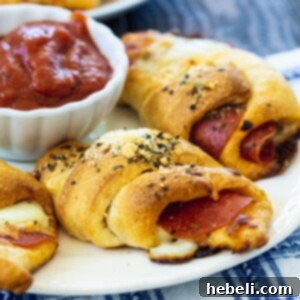 Pepperoni Crescent Rolls on a plate with bowl of marinara.