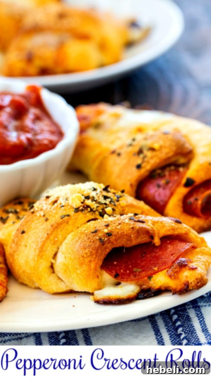 A delicious plate of Pepperoni Crescent Rolls, perfectly baked and golden, served with a rich pizza dipping sauce, ready to be enjoyed.