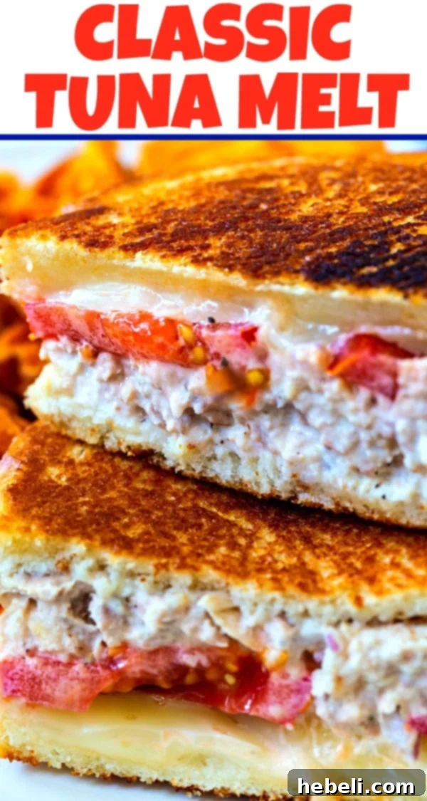 Golden Tuna Melt 6 A neatly plated Classic Tuna Melt, sliced in half, with a garnish of fresh herbs.