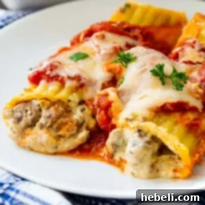 Two Italian Sausage Manicotti on a white plate with sauce.