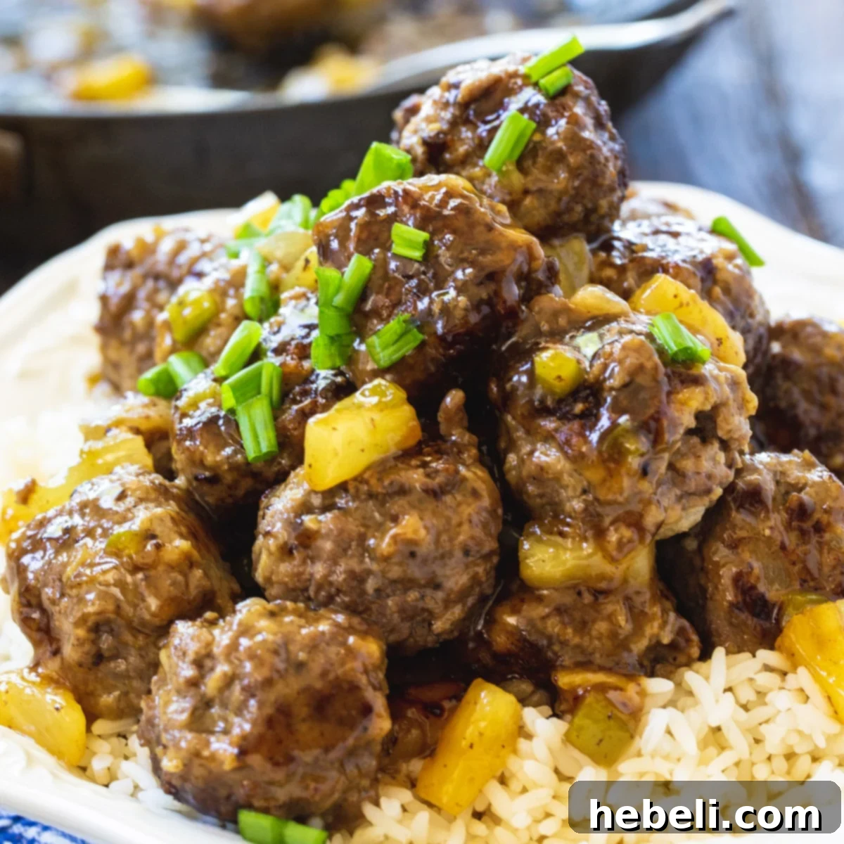 Polynesian Meatballs over rice on a plate.