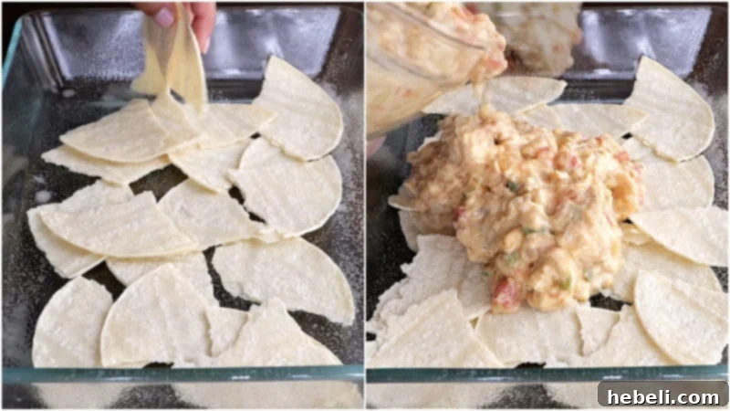 The first layers of King Ranch Chicken Casserole in a baking dish, showing tortillas at the bottom and the chicken mixture spread on top.