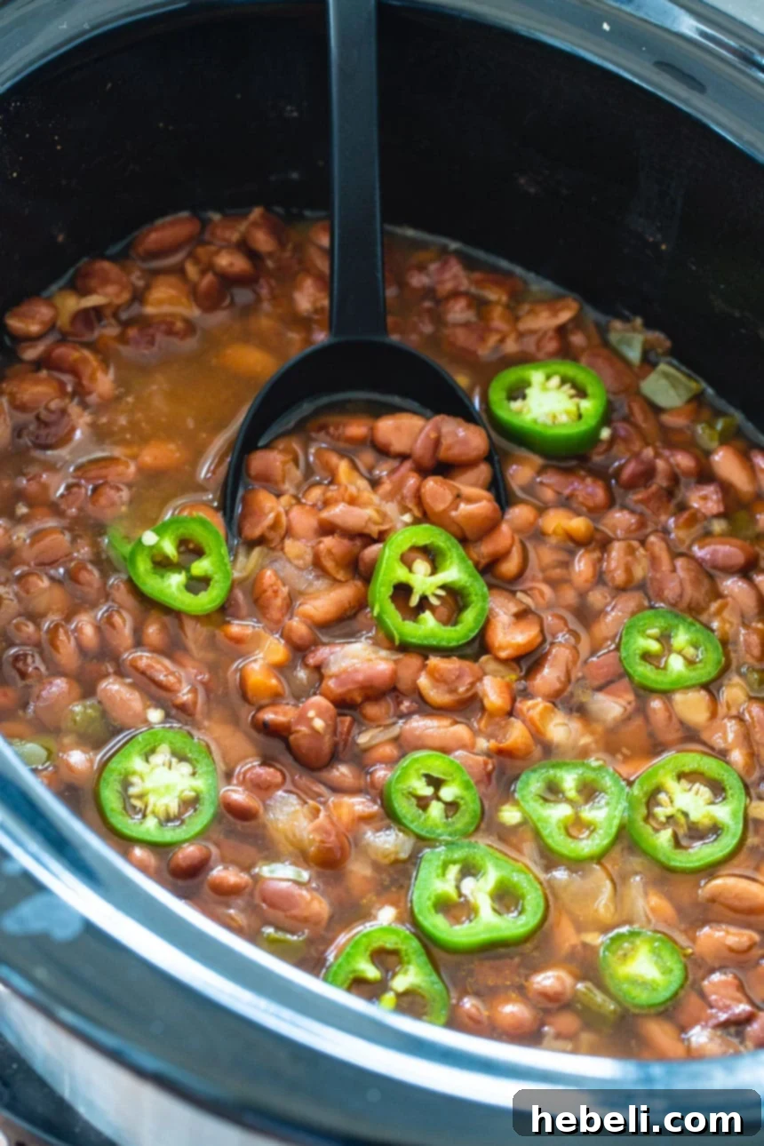 Hearty Slow Cooker Spicy Pinto Beans 3 Spicy Pinto Beans in a black crock pot.